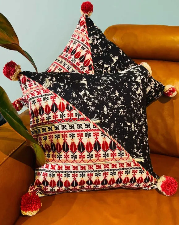 Decorative pillow with geometric pattern and pom-poms on a couch, Sapling Textiles, Fabric Store Australia, Indian Fabric online Australia