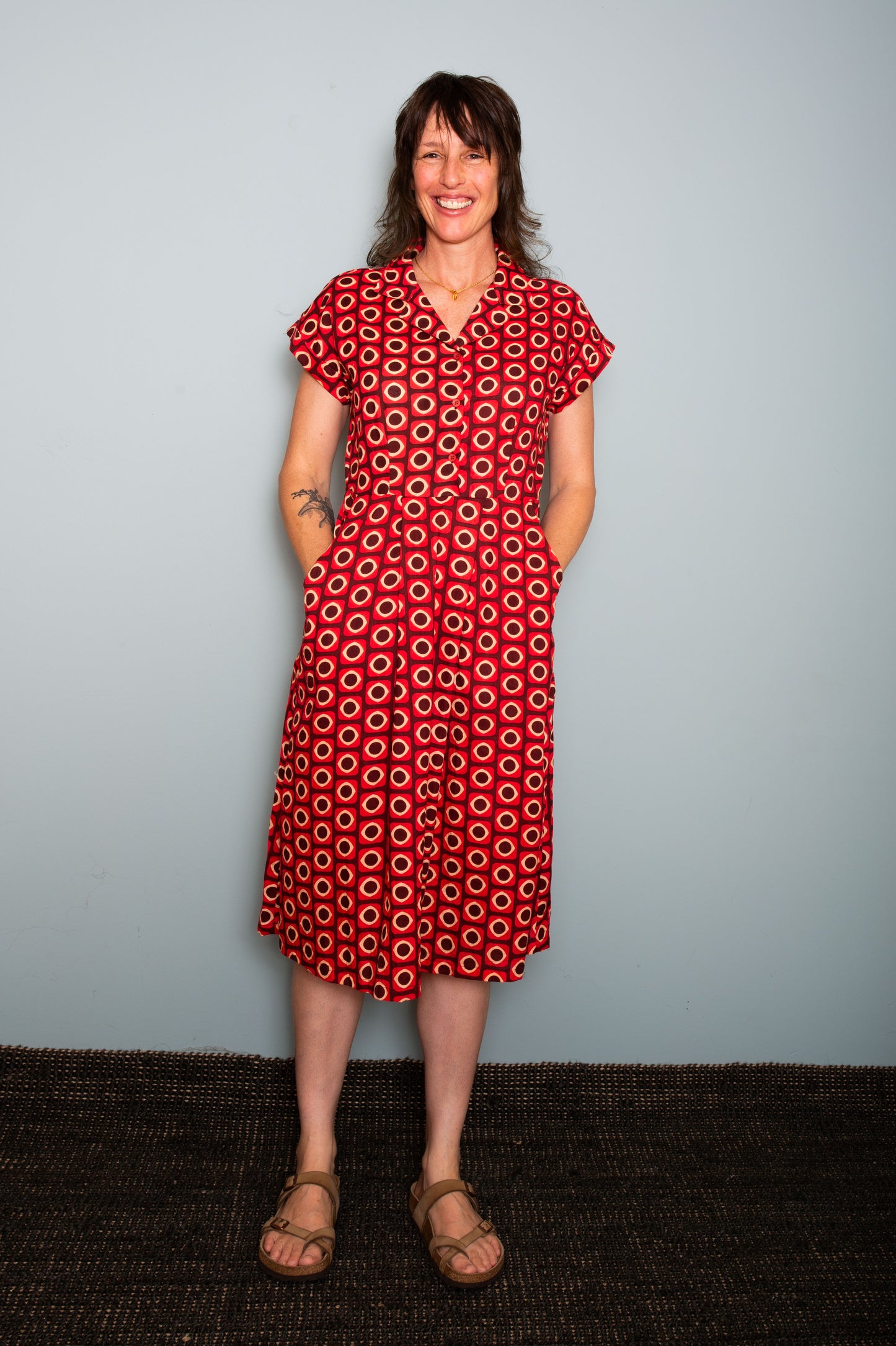 Woman wearing a patterned dress standing against a plain background,  Sapling Textiles, Fabric Store Australia, Indian Fabric online Australia