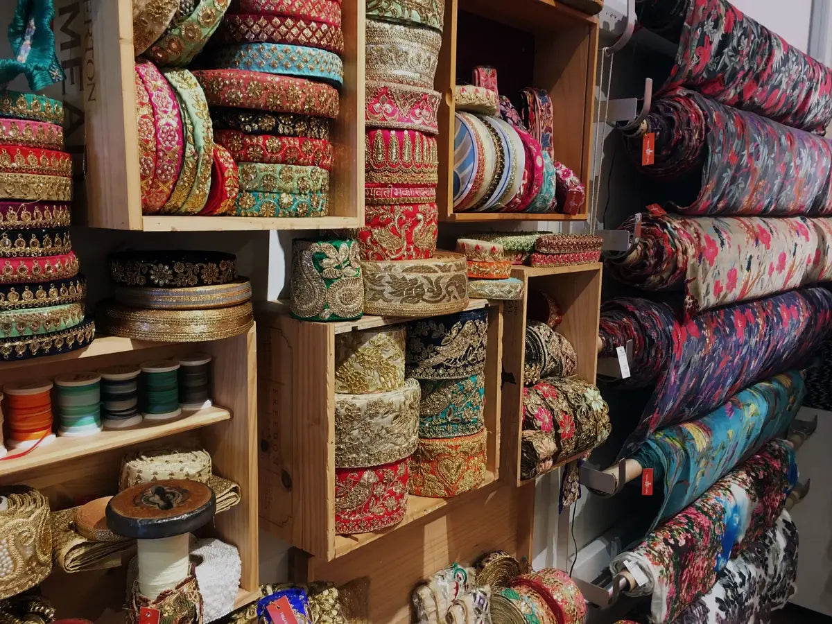 Display of colorful fabric rolls and spools in a store setting, Sapling Textiles, Fabric Store Australia, Indian Fabric online Australia